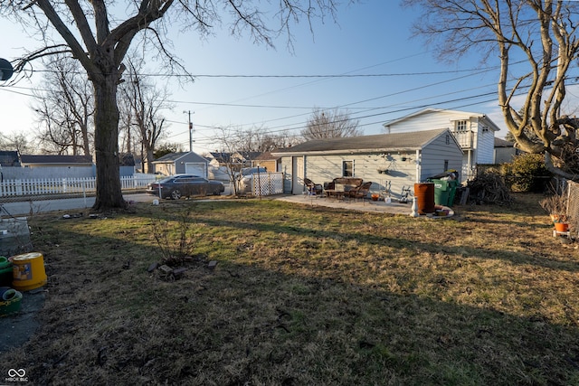 view of yard featuring fence, an outdoor structure, and a patio