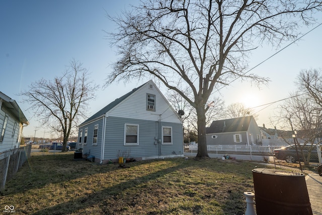 view of side of home with a lawn and a fenced backyard