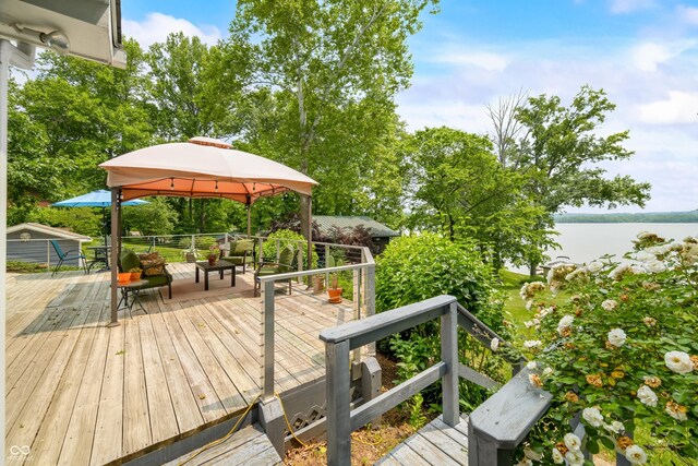 7600 N Blue Heron Dr, Unionville, IN 47468 - wooden terrace featuring a gazebo, an outdoor hangout area, and a water view
