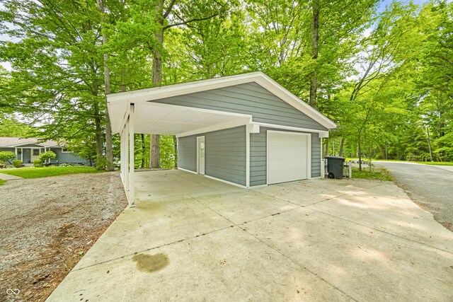 7600 N Blue Heron Dr, Unionville, IN 47468 - garage featuring concrete driveway, view of scattered trees, and a garage