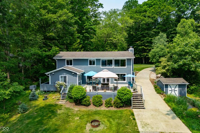 7600 N Blue Heron Dr, Unionville, IN 47468 - view of front facade featuring stairs, a deck, a chimney, and a front yard