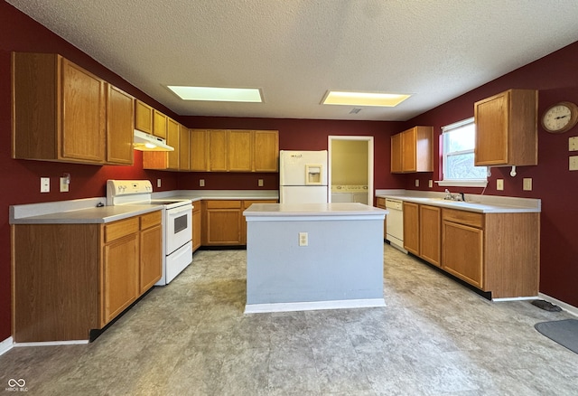 kitchen with light floors, white appliances, a center island, and under cabinet range hood