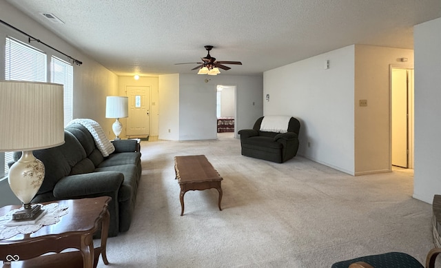 living room with light carpet, ceiling fan, a textured ceiling, and visible vents