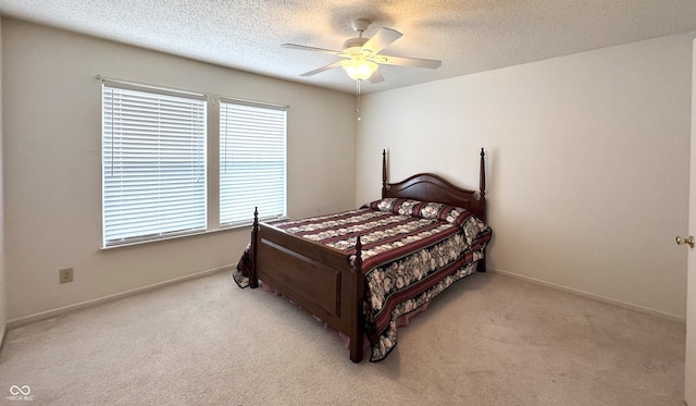 carpeted bedroom featuring ceiling fan, baseboards, and a textured ceiling