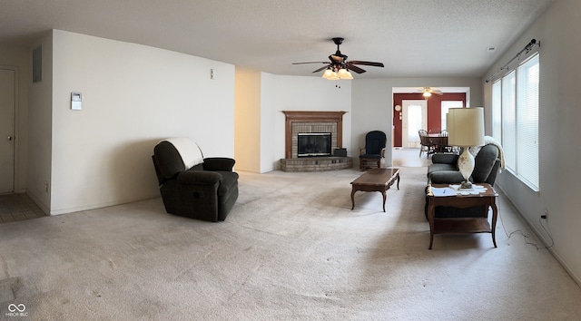 living area featuring carpet floors, a brick fireplace, visible vents, and a textured ceiling