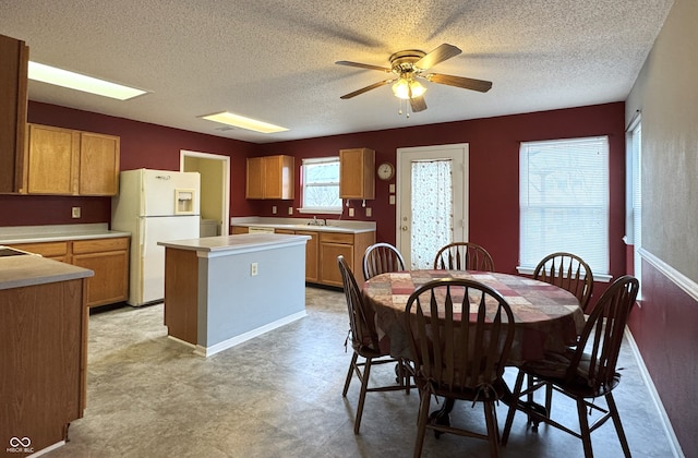 dining room featuring a ceiling fan, a textured ceiling, and light floors