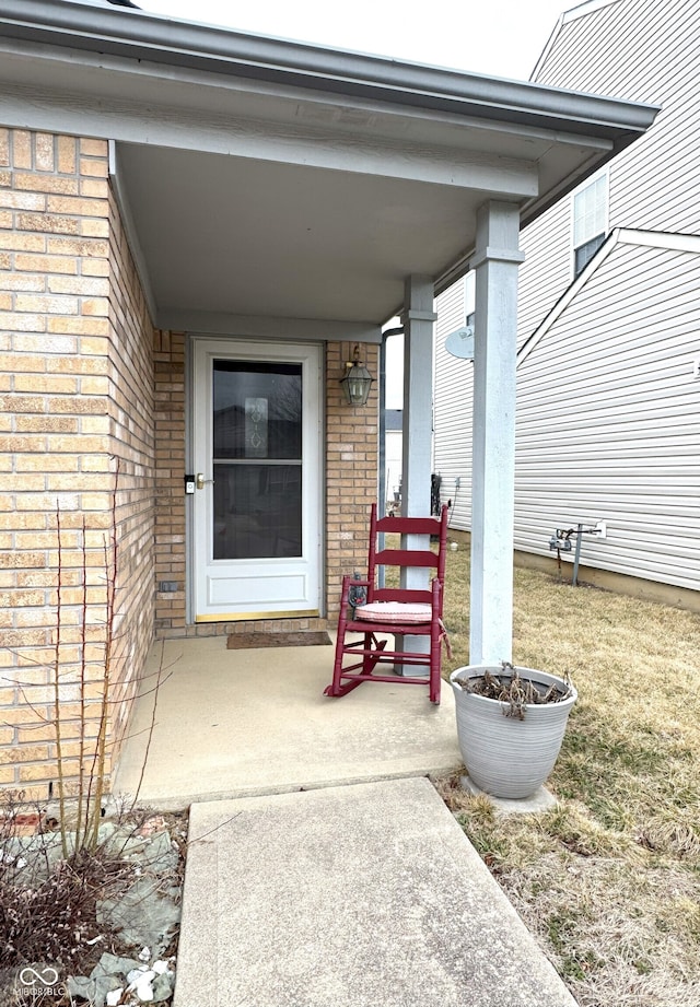 doorway to property featuring brick siding