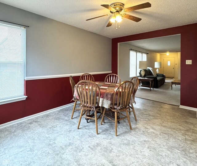 dining room featuring ceiling fan, baseboards, and a textured ceiling