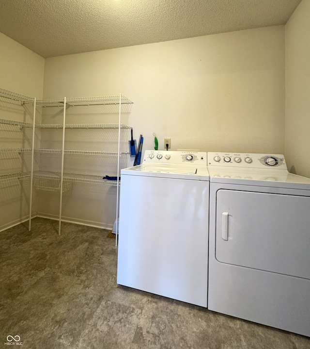 washroom featuring laundry area, a textured ceiling, and washer and dryer