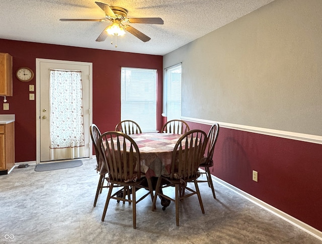 dining room with a ceiling fan, a textured ceiling, and baseboards