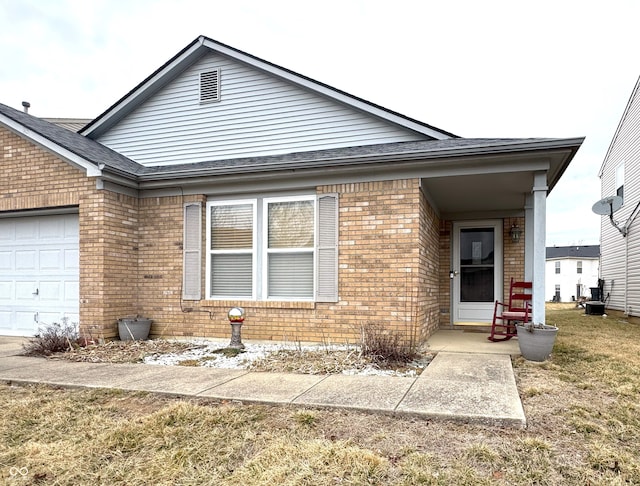 view of front facade with a garage, a front lawn, and brick siding