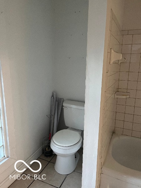 full bath featuring baseboards, toilet, and tile patterned floors