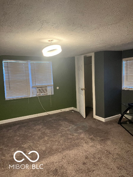 interior space with a textured ceiling and baseboards