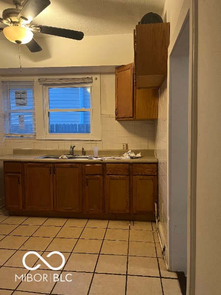 kitchen featuring light tile patterned floors, a ceiling fan, and decorative backsplash