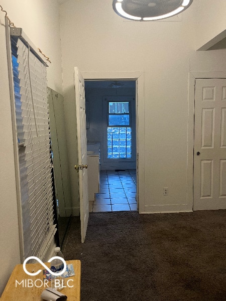 hallway with carpet floors and tile patterned floors