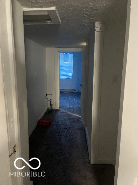 hallway with a baseboard radiator, carpet flooring, and a textured ceiling