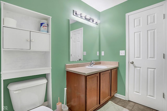 half bathroom with toilet, tile patterned floors, and vanity