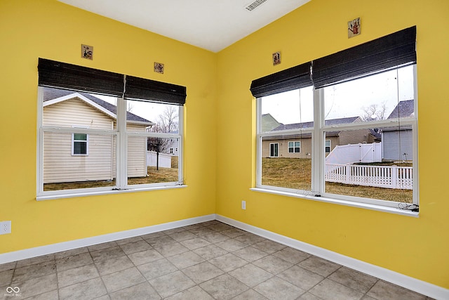 unfurnished room with baseboards and tile patterned floors