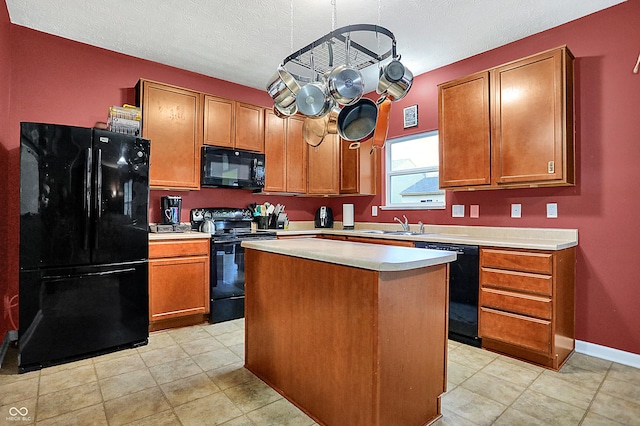 kitchen featuring baseboards, a center island, light countertops, black appliances, and a sink