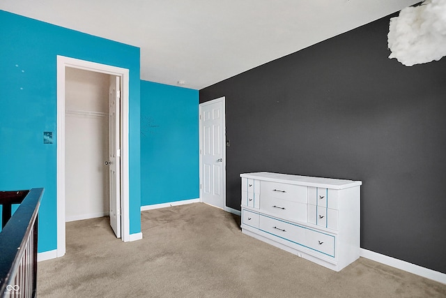 unfurnished bedroom with a closet, light carpet, and baseboards