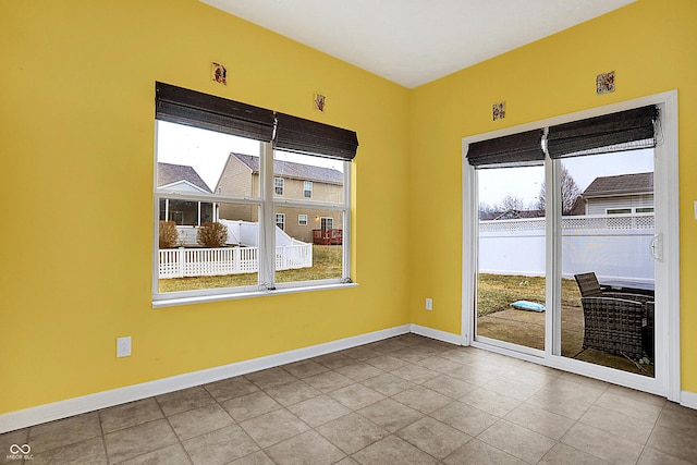 unfurnished room with baseboards and tile patterned floors