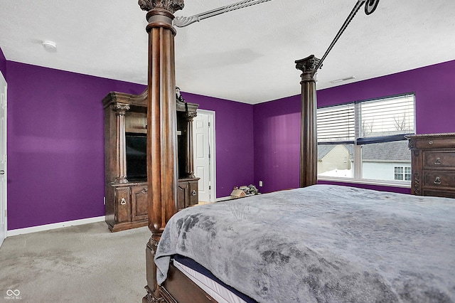 bedroom with a textured ceiling, carpet floors, visible vents, and baseboards