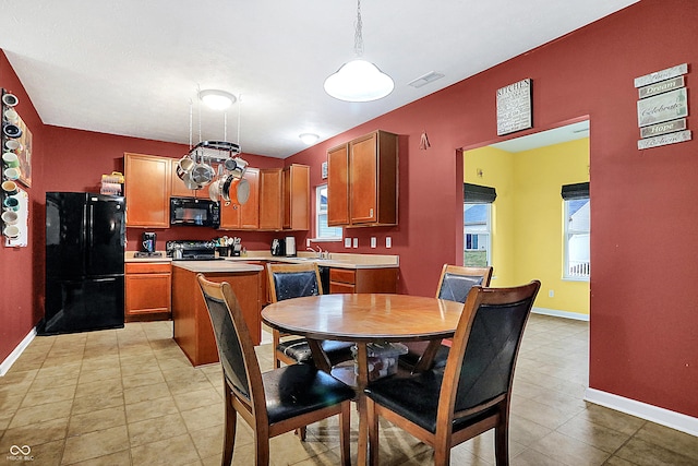 kitchen with visible vents, baseboards, hanging light fixtures, light countertops, and black appliances