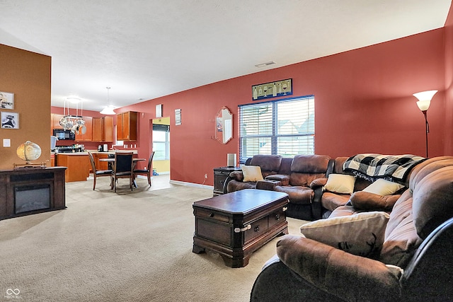 living room featuring light carpet, baseboards, visible vents, and a healthy amount of sunlight