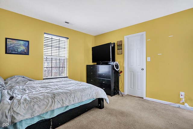 bedroom featuring light carpet, baseboards, and visible vents