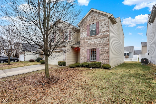 traditional home with concrete driveway, an attached garage, fence, a front lawn, and brick siding