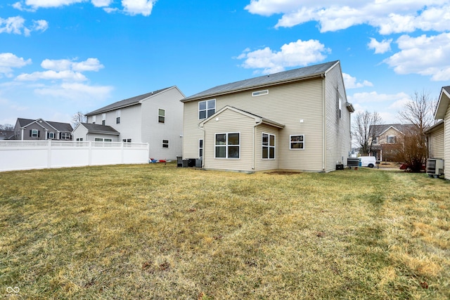 rear view of house featuring a yard and fence