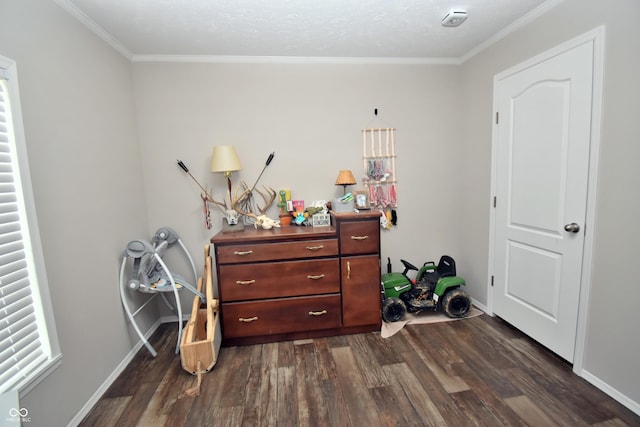 bedroom with dark wood-style floors, crown molding, and baseboards