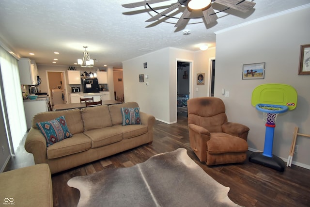 living area featuring dark wood-style floors, a textured ceiling, baseboards, and crown molding