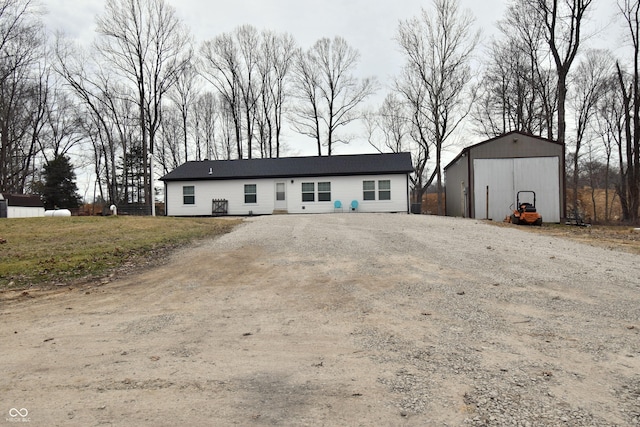 view of front of property with a garage, driveway, and an outdoor structure