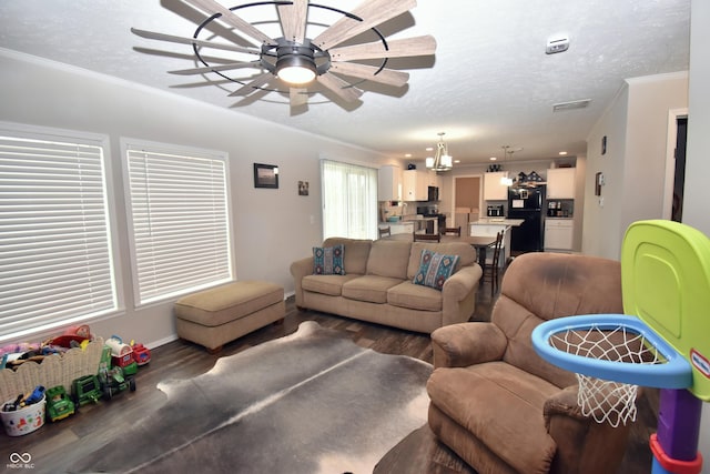 living room featuring a textured ceiling, wood finished floors, a ceiling fan, and crown molding