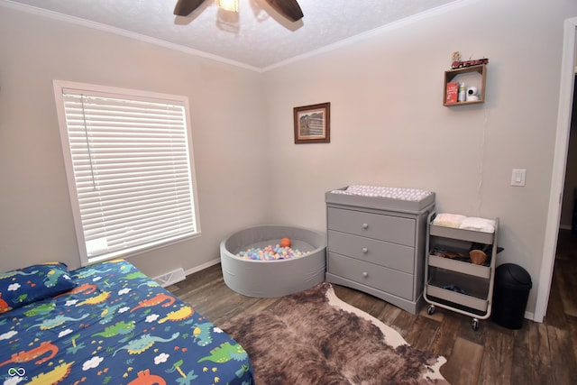 bedroom with baseboards, visible vents, a ceiling fan, wood finished floors, and crown molding