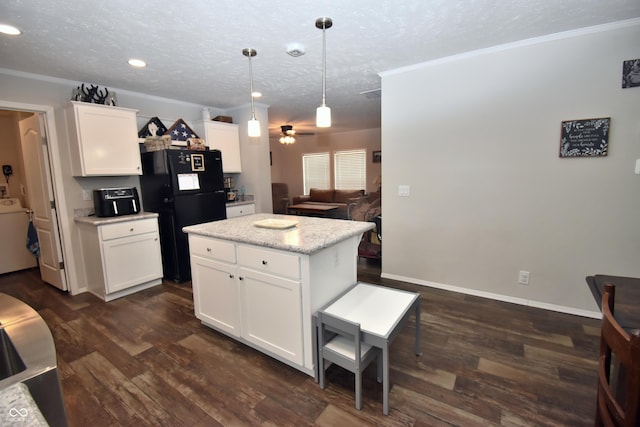 kitchen with a textured ceiling, dark wood-style flooring, freestanding refrigerator, and crown molding