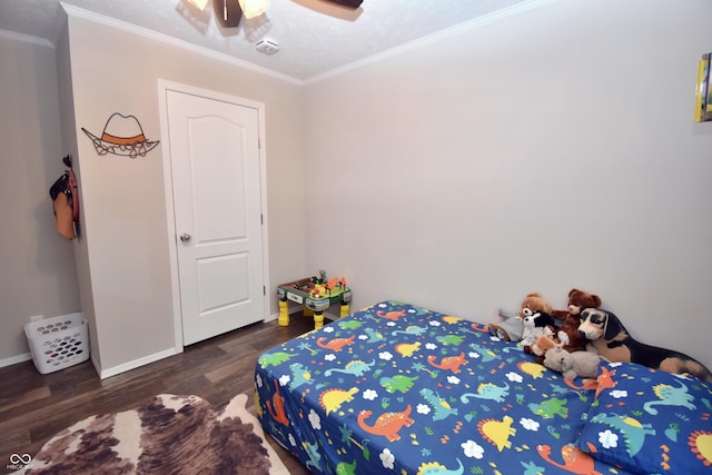 bedroom featuring baseboards, a ceiling fan, wood finished floors, crown molding, and a textured ceiling