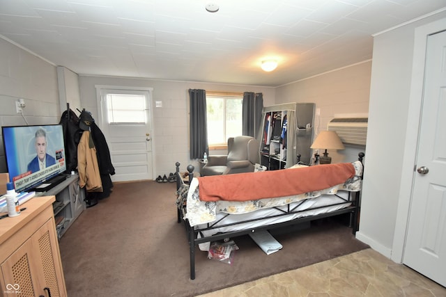 bedroom featuring concrete block wall and light carpet