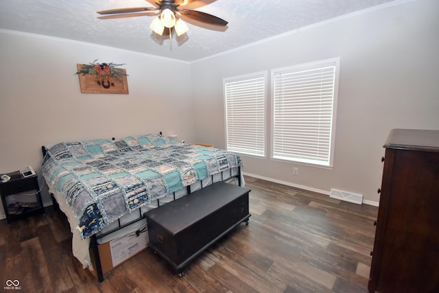 bedroom with ornamental molding, visible vents, a textured ceiling, and wood finished floors