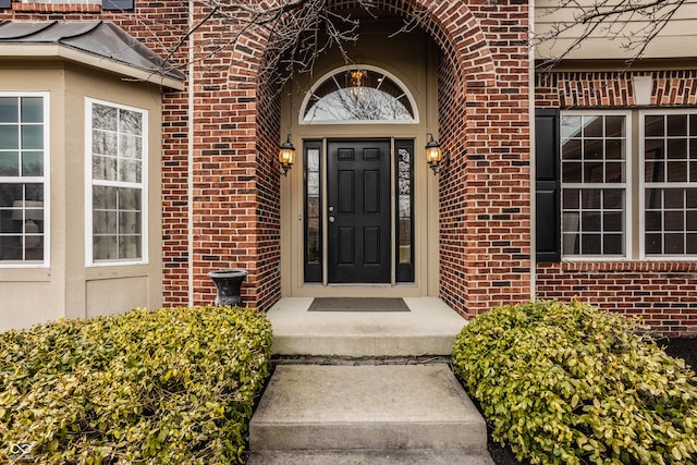 view of exterior entry with brick siding