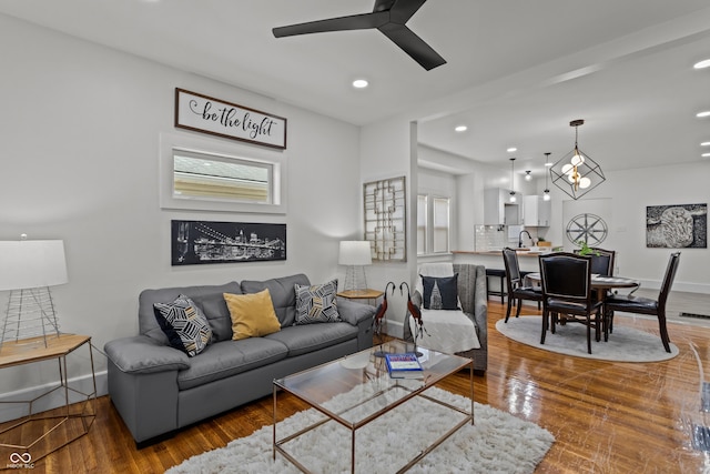 living area featuring recessed lighting, wood finished floors, a ceiling fan, and baseboards