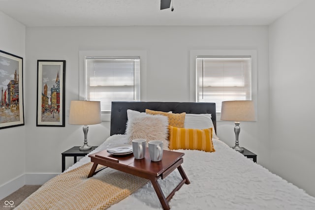 carpeted bedroom with baseboards and a ceiling fan