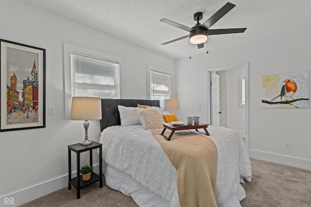 carpeted bedroom featuring a ceiling fan, a textured ceiling, and baseboards