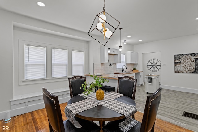 dining room featuring light wood-style flooring, visible vents, baseboards, and recessed lighting