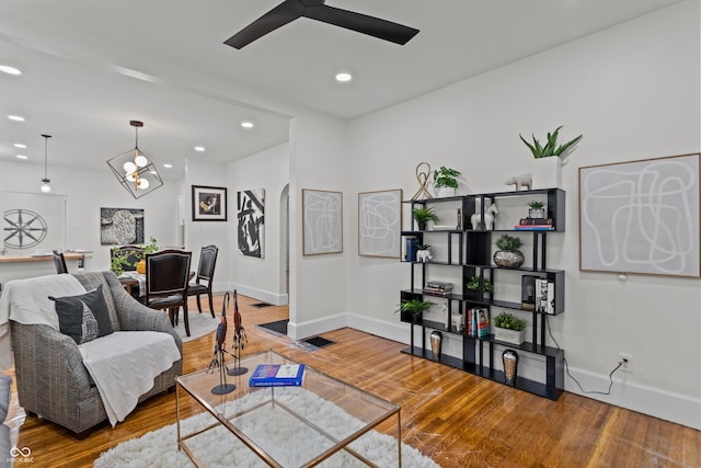 living area with baseboards, ceiling fan, wood finished floors, and recessed lighting