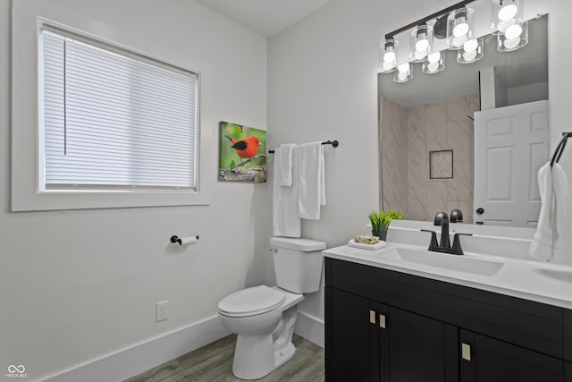 full bathroom featuring baseboards, toilet, wood finished floors, walk in shower, and vanity