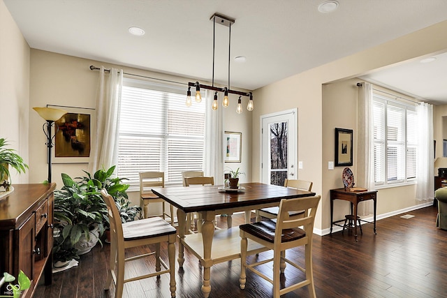 dining space featuring dark wood-type flooring and baseboards