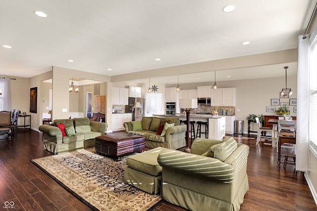 living area with recessed lighting, dark wood-style flooring, and baseboards