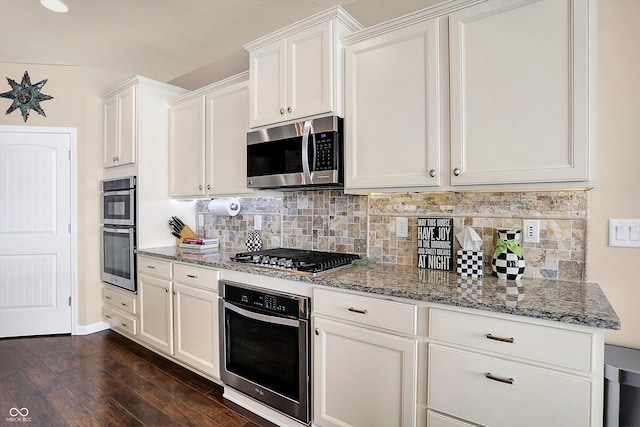 kitchen with light stone counters, stainless steel appliances, tasteful backsplash, and dark wood-style flooring